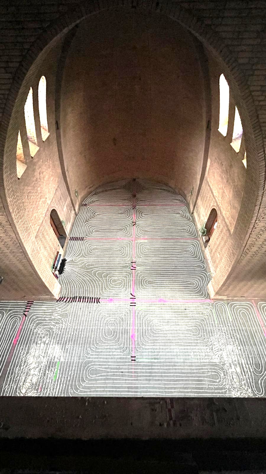 Overzicht van de vloerverwarming in het kerkschip tijdens de bouw